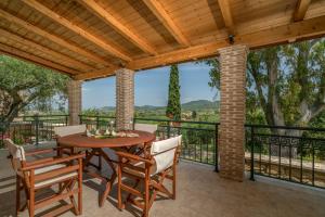 a patio with a table and chairs on a balcony at Aelia Villa in Kallithea