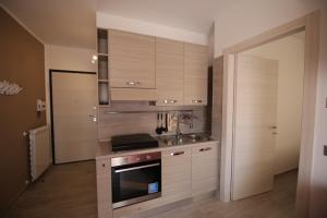una cucina con armadi in legno e piano cottura. di Holiday House Alba ad Alba Adriatica