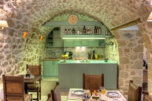 ネオ・イティロにあるVetilios Lithos boutique hotelの石壁のキッチン(緑のキャビネット付)