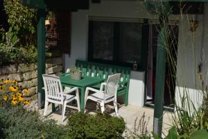 una mesa verde y sillas en un patio en Tango Ferienwohnung Winnenden, en Winnenden