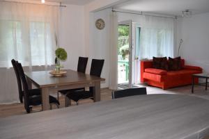 sala de estar con mesa y sofá rojo en Tango Ferienwohnung Winnenden, en Winnenden