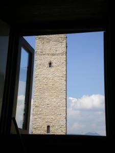 a tall brick tower is seen through a window at Casa Mario Lupo - Apartments and Rooms in Bergamo