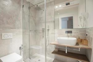 a bathroom with a sink and a glass shower at Le Scuderie B&B in Arco