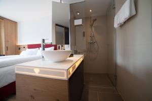 a bathroom with a sink, toilet and bathtub at Diamond City Hotel Tulln in Tulln