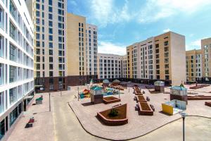 une cour dans une ville avec des bancs et des bâtiments dans l'établissement Apartments Promenade Expo, à Astana