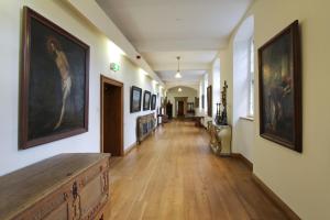 a long hallway with paintings on the walls at Abdij Hotel Rolduc in Kerkrade