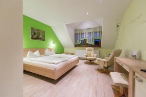 ein Schlafzimmer mit einem Bett und einer grünen Wand in der Unterkunft Weingut Karl Braun in Nordheim