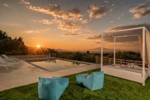 een villa met een zwembad en een zonsondergang bij Merovigli Villa in Tragaki