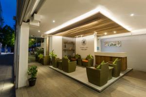 a waiting room with green chairs in a building at Coconut Tree Hulhuvilla Beach in Hulhumale