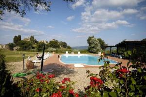 una piscina con persone sedute intorno di Farmhouse Tuscany a Montecastelli