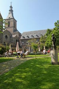 a park with a statue in front of a building at Abdij Hotel Rolduc in Kerkrade