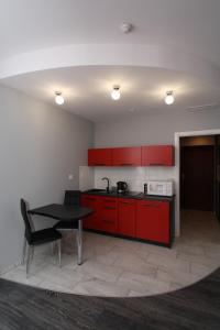 コウォブジェクにあるPoppy Apartment Kolobrzegの赤いキャビネットと黒いテーブル付きのキッチン