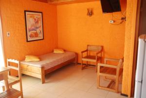 a small bedroom with a bed and two chairs at Cabañas Diquen's El Tabo in El Tabo