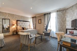 Pokój hotelowy z łóżkiem, biurkiem i krzesłami w obiekcie Villa Lutèce Port Royal w Paryżu