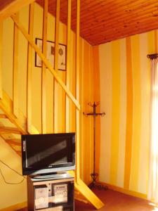 a living room with a tv and a cross on the wall at Ecochiocciola in Montese