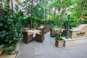 an outdoor patio with tables and chairs and plants at Hotel Irisa in Bucharest
