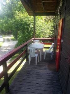 a porch with a table and two chairs on it at Ecochiocciola in Montese