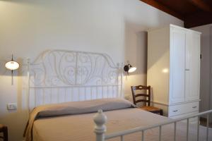 ein Schlafzimmer mit einem weißen Bett und einem weißen Schrank in der Unterkunft Agriturismo "Terra D'Ulivi" in Porto Cesareo