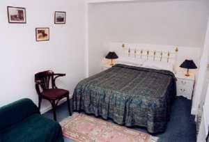 1 dormitorio con 1 cama, 1 silla y 1 sofá en Milton House, en Edimburgo