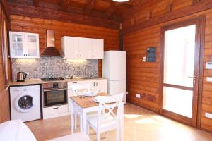 - une cuisine avec des appareils blancs et un mur en bois dans l'établissement Agli Ulivi Cefalù - by Vacation Service, à Cefalù