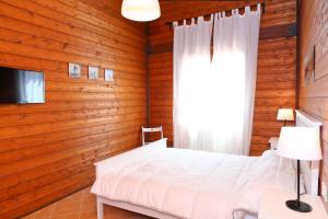 - une chambre avec des murs en bois, un lit et une fenêtre dans l'établissement Agli Ulivi Cefalù - by Vacation Service, à Cefalù