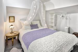 ein Schlafzimmer mit einem weißen Bett mit Baldachin in der Unterkunft Alfama Cosy & Charming in Lissabon