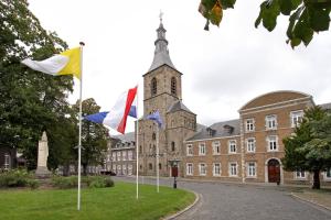 two flags on poles in front of a building at Abdij Hotel Rolduc in Kerkrade