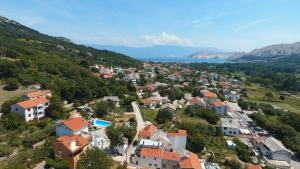 eine Luftansicht einer Kleinstadt auf einem Hügel in der Unterkunft Apartmani Mihaela II in Baška
