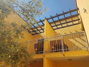 un bâtiment jaune avec un chien dans une cage sur un balcon dans l'établissement Villa Alpa, à Umag