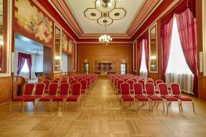 a large room with red chairs and a chandelier at Focus Hotel Premium Pod Orłem in Bydgoszcz