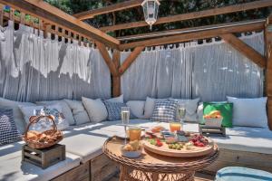 a patio with a couch and a table with food at ECO Aparthotel The Dreamers's Club in Lumbarda