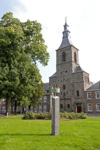 a statue in front of a building with a tower at Abdij Hotel Rolduc in Kerkrade
