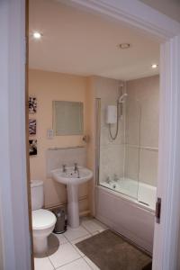 La salle de bains est pourvue d'un lavabo, de toilettes et d'une douche. dans l'établissement City Centre Luxury Holiday Apartment, à Liverpool