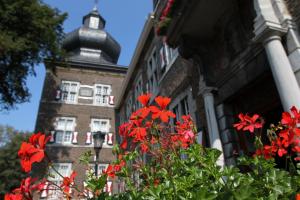 a building with red flowers in front of it at Abdij Hotel Rolduc in Kerkrade