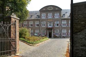 an entrance to a large brick building with a gate at Abdij Hotel Rolduc in Kerkrade