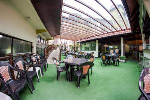 un restaurante con mesas y sillas y techo de cristal en Hotel Kirst en Piratuba