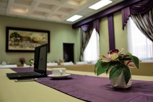 a table with a laptop and a vase with a flower at Hotel Plaza Campeche in Campeche