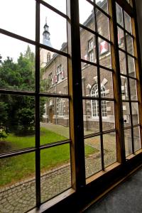 an open window looking out at a brick building at Abdij Hotel Rolduc in Kerkrade
