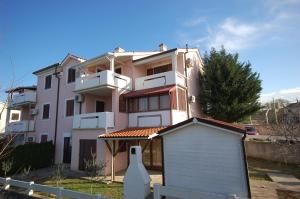 a pink building with a smallshed in front of it at Apartment Zlatica by El-Pi Tours in Malinska