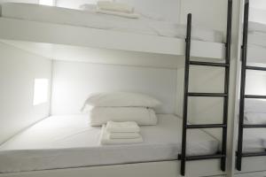 a white bunk bed with white pillows and a mirror at Globetrotter Hostel in León