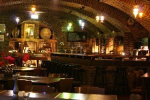 a restaurant with tables and chairs and a bar at Abdij Hotel Rolduc in Kerkrade