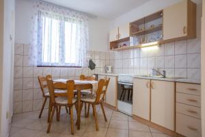 eine Küche mit einem Tisch und Stühlen im Zimmer in der Unterkunft Apartment Zora - Guest house in Ogulin