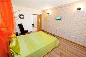 a bedroom with a green bed and a tv on the wall at Apartament Gina2 in Galaţi