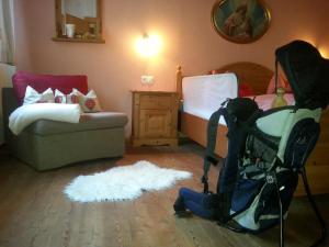a living room with a baby stroller and a bed at Chalet Tyrol in Fügen