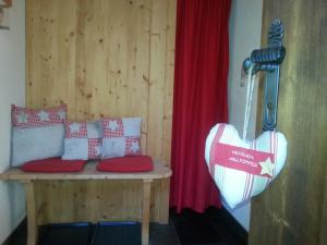 een kamer met een bank en een hart aan de muur bij Chalet Tyrol in Fügen
