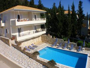 a villa with a swimming pool in front of a house at Geni Garden Apartments in Yenion
