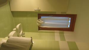 Bar Trattoria Colombina Affittacamere في Bossico: حمام به مرحاض وتلفزيون على الحائط