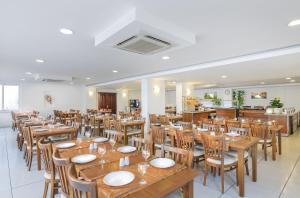 une salle à manger avec des tables et des chaises en bois dans l'établissement Club Shark Hotel, à Gumbet
