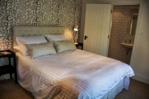 a bedroom with a large bed and a sink at Ivythorpe Coach House in Bath