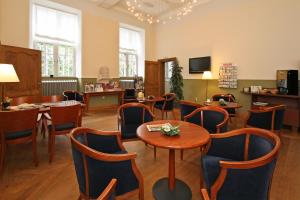 um restaurante com mesas e cadeiras num quarto em Abdij Hotel Rolduc em Kerkrade